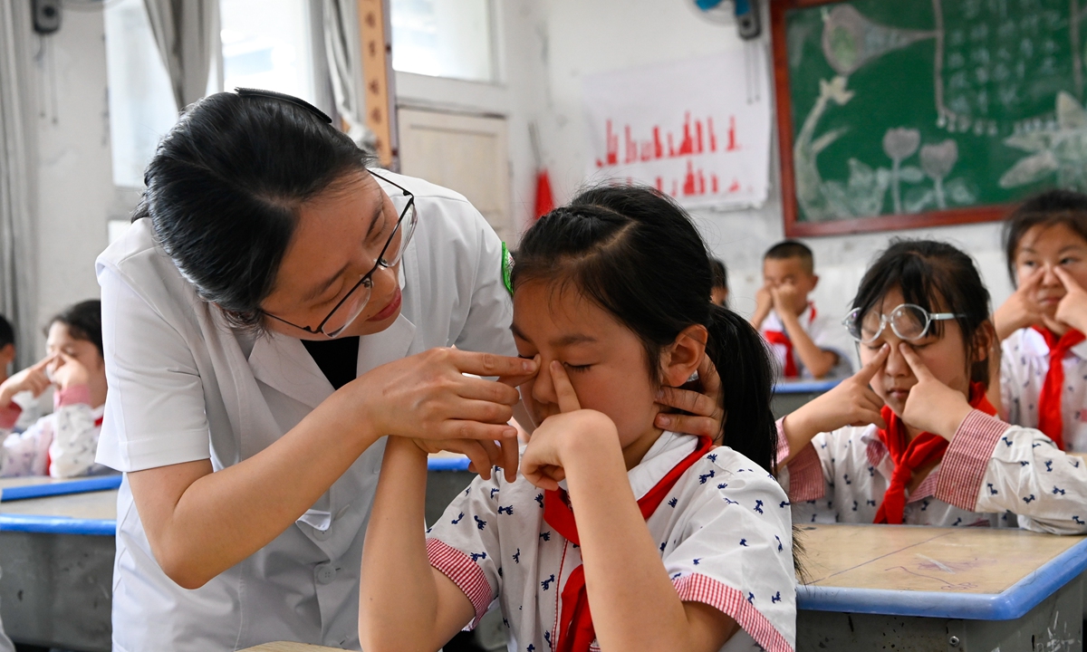 An ophthalmologist from a county hospital explains eye care and eye protection to elementary school students, carries out vision checkups, and enhances children's awareness of eye care and eye protection in Southwest China's Chongqing Municipality on June 5, 2025, ahead of China's