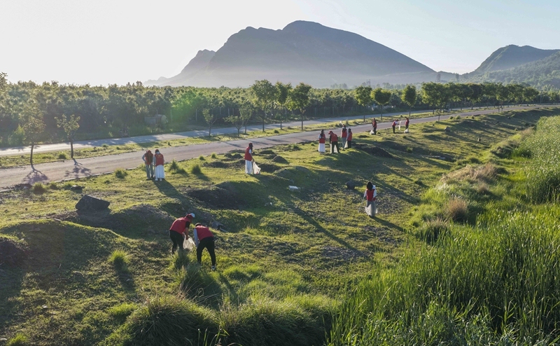 An aerial drone photo taken on June 4, 2025 shows volunteers collecting wastes along a riverbank in Zunhua City, north China's Hebei Province. Photo: Xinhua
