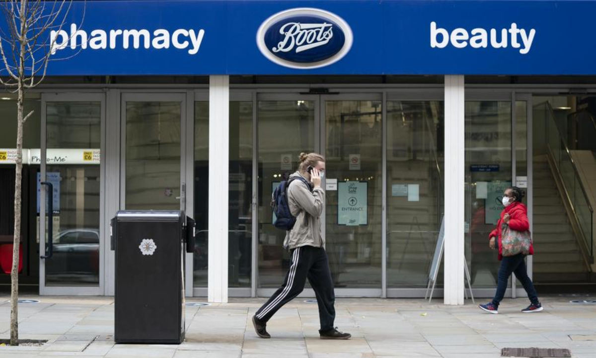 People walk past a Boots store in Manchester, Britain, on July 9, 2020. (Photo by Jon Super/Xinhua)