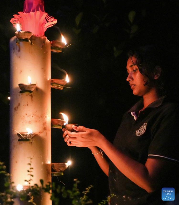 A Buddhist devotee lights up the oil lamps to celebrate Poson Poya Day in Ratnapura, Sri Lanka, June 10, 2025.
Poson Poya Day marks the arrival of Buddhism in Sri Lanka. (Photo by Thilina Kaluthotage/Xinhua)