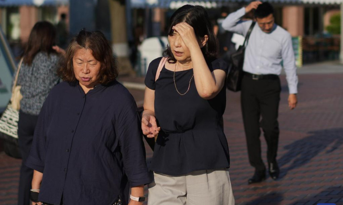 Pedestrians walk on a street in Tokyo, Japan, June 18, 2025. Tokyo and other regions in Japan have been hit by high temperatures in recent days. (Xinhua/Jia Haocheng)