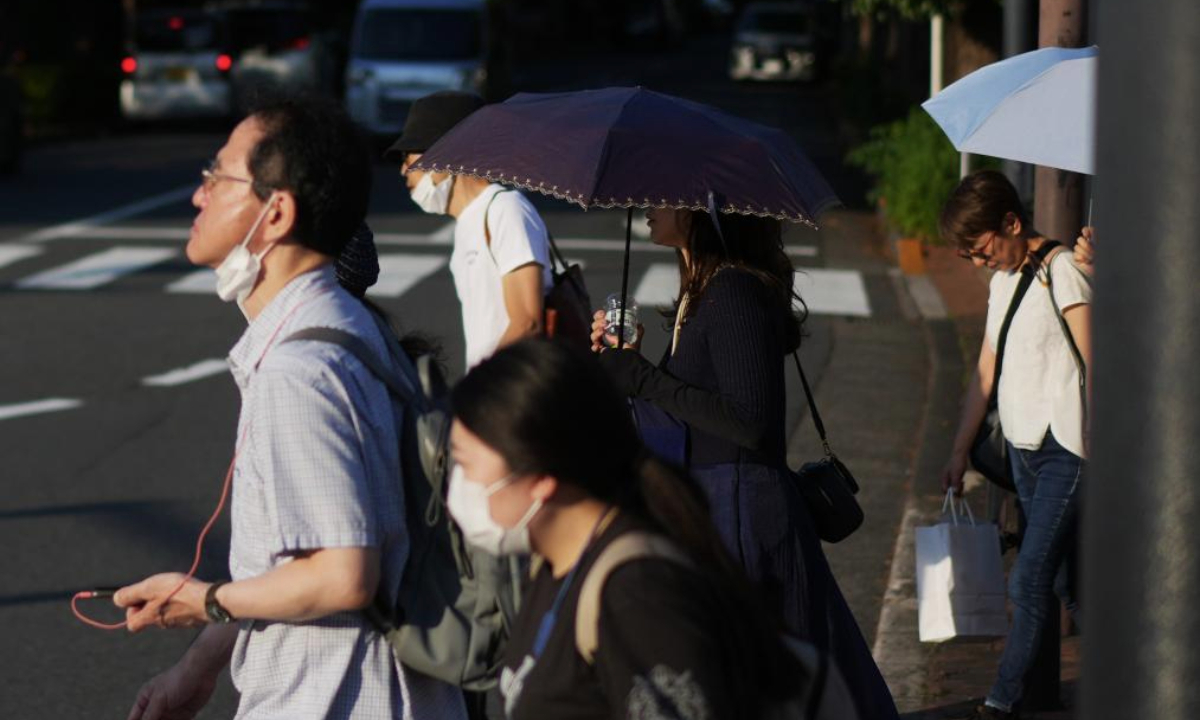 Pedestrians walk on a street in Tokyo, Japan, June 18, 2025. Tokyo and other regions in Japan have been hit by high temperatures in recent days. (Xinhua/Jia Haocheng)