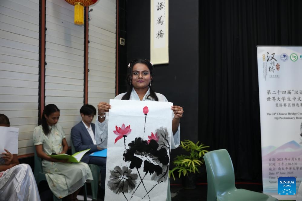 A contestant shows her traditional Chinese painting during the 24th Chinese Bridge Chinese Proficiency Competition for college students in Suva, Fiji, June 6, 2025. (Photo: Xinhua)