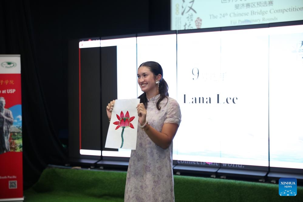 A contestant shows her traditional Chinese painting during the 24th Chinese Bridge Chinese Proficiency Competition for college students in Suva, Fiji, June 6, 2025. (Photo: Xinhua)