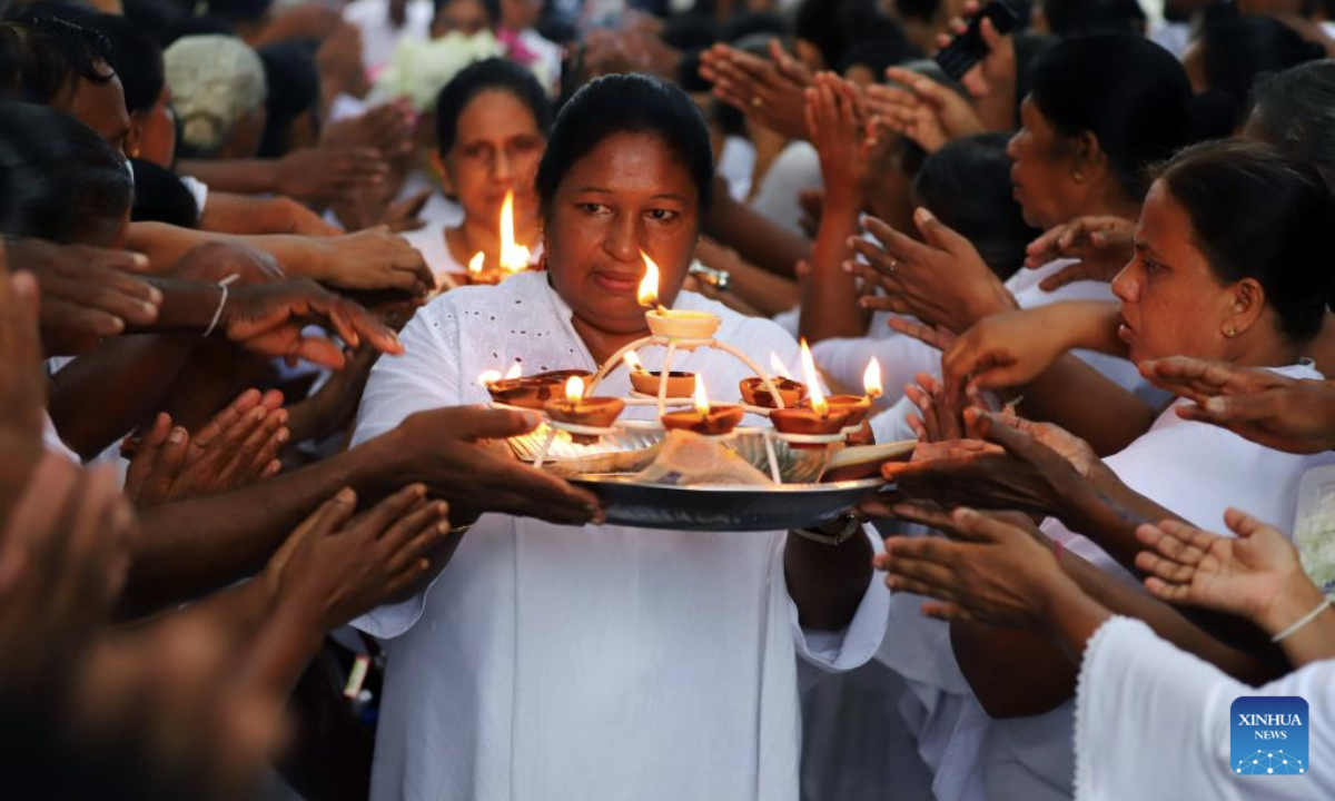 Buddhist devotees participate in a religious ritual on Poson Poya Day at a temple in Kelaniya, Sri Lanka, June 10, 2025.
Poson Poya Day marks the arrival of Buddhism in Sri Lanka. (Photo by Ajith Perera/Xinhua)