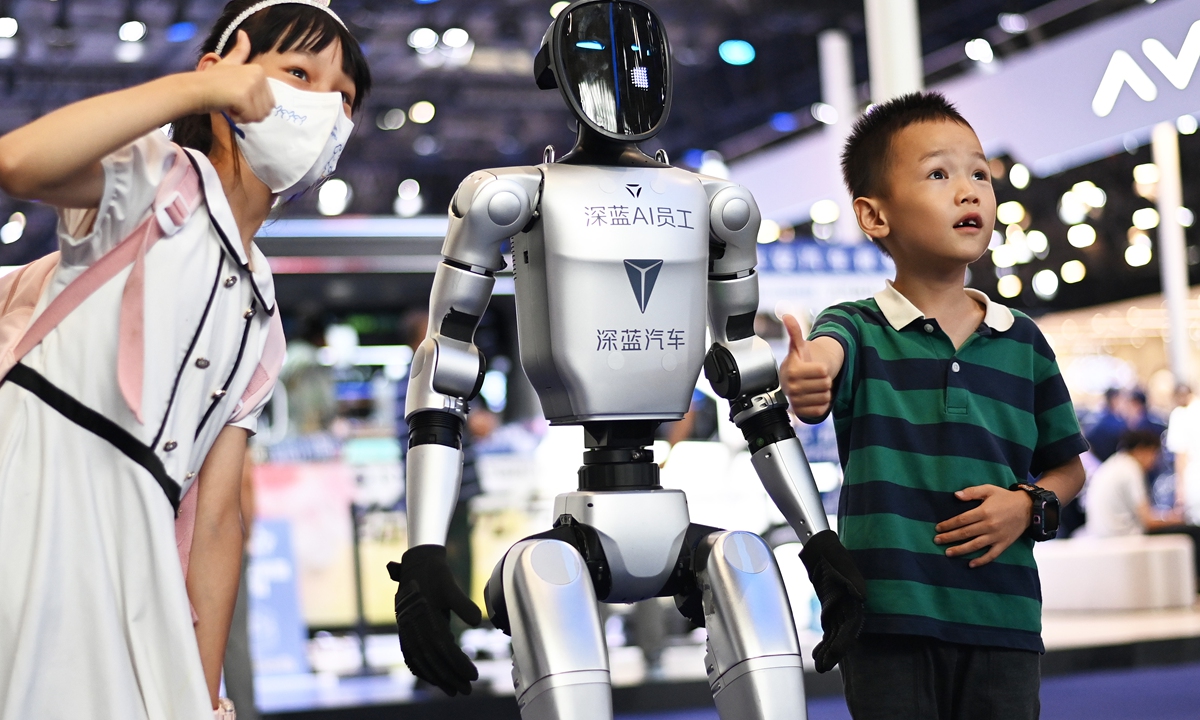 Children interact with a robot at the Chongqing International Auto Exhibition 2025 in Chongqing Municipality on June 8, 2025. With an exhibition area of 160,000 square meters, the event brings 1,046 models and 93 new car releases, injecting strong momentum into the local auto industry's development. Photo: VCG