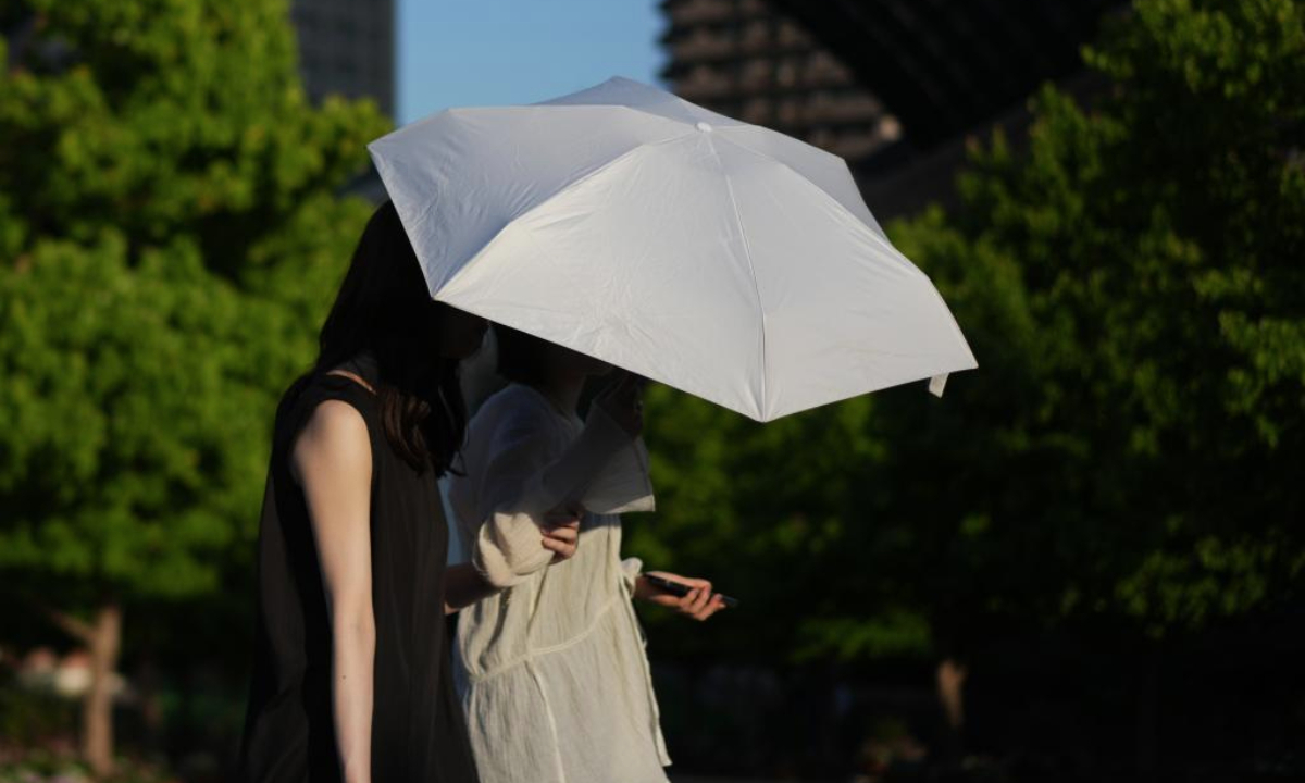 Pedestrians walk on a street in Tokyo, Japan, June 18, 2025. Tokyo and other regions in Japan have been hit by high temperatures in recent days. (Xinhua/Jia Haocheng)