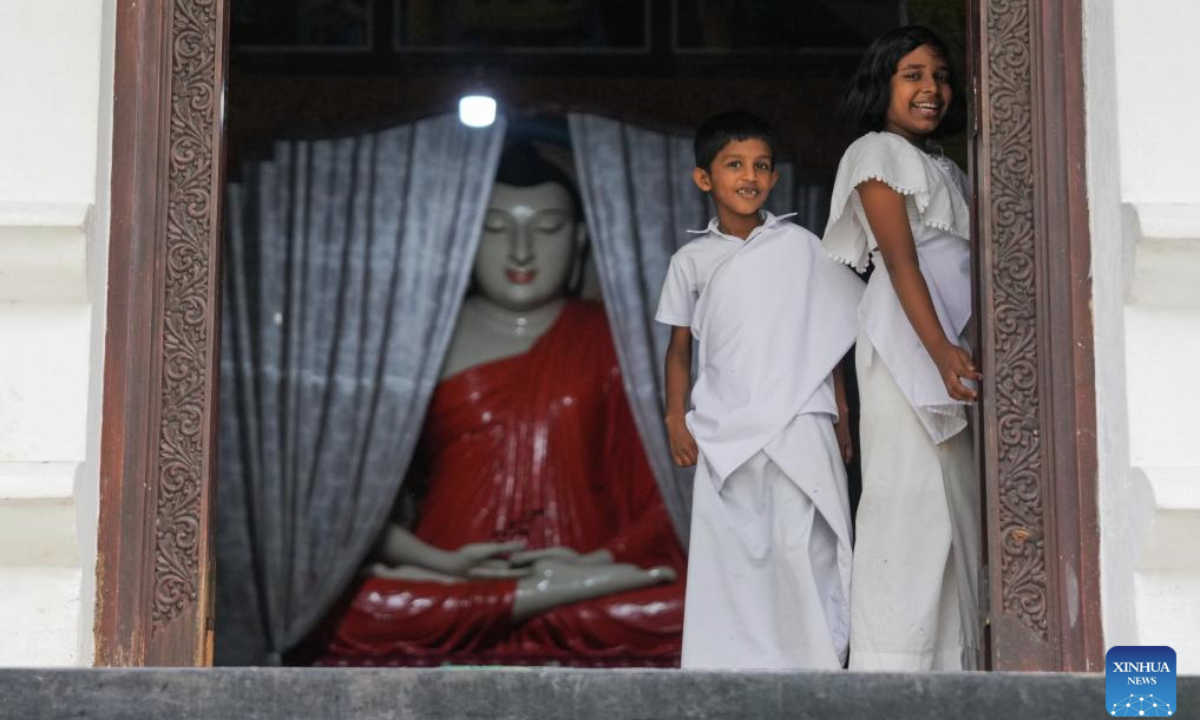 Children are pictured at a Buddhist temple in Ratnapura, Sri Lanka on Poson Poya Day, June 10, 2025.
Poson Poya Day marks the arrival of Buddhism in Sri Lanka. (Photo by Thilina Kaluthotage/Xinhua)
