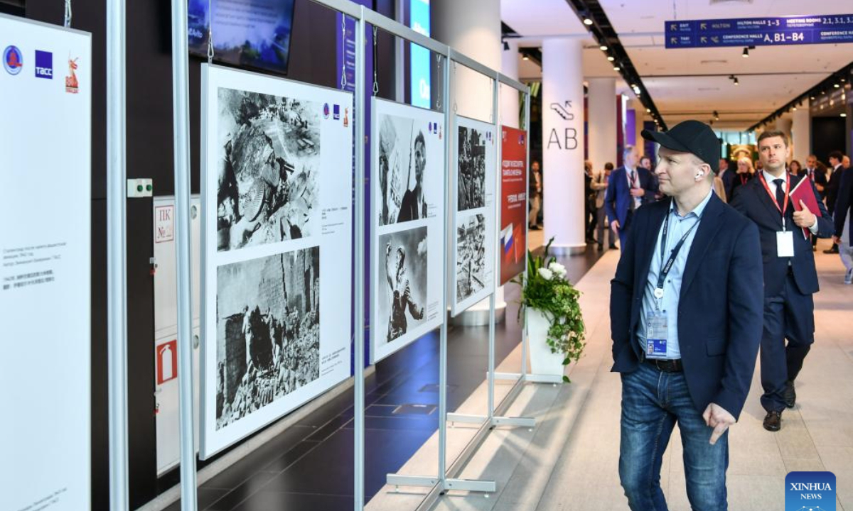 People visit a photo exhibition marking the 80th anniversary of the victory of the World Anti-Fascist War in St. Petersburg, Russia, June 19, 2025. Titled Immortal Merits, Eternal Memory, the exhibition was co-hosted by Xinhua News Agency and TASS news agency. (Xinhua/Cao Yang)