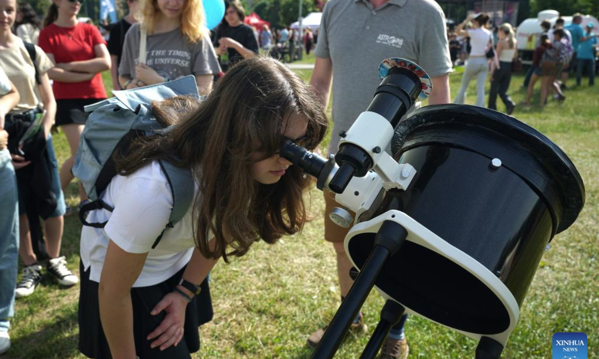 A girl looks through a telescope at Science Fest, a fun open-air science festival, in Prague, the Czech Republic, on June 18, 2025. (Photo by Dana Kesnerova/Xinhua)
