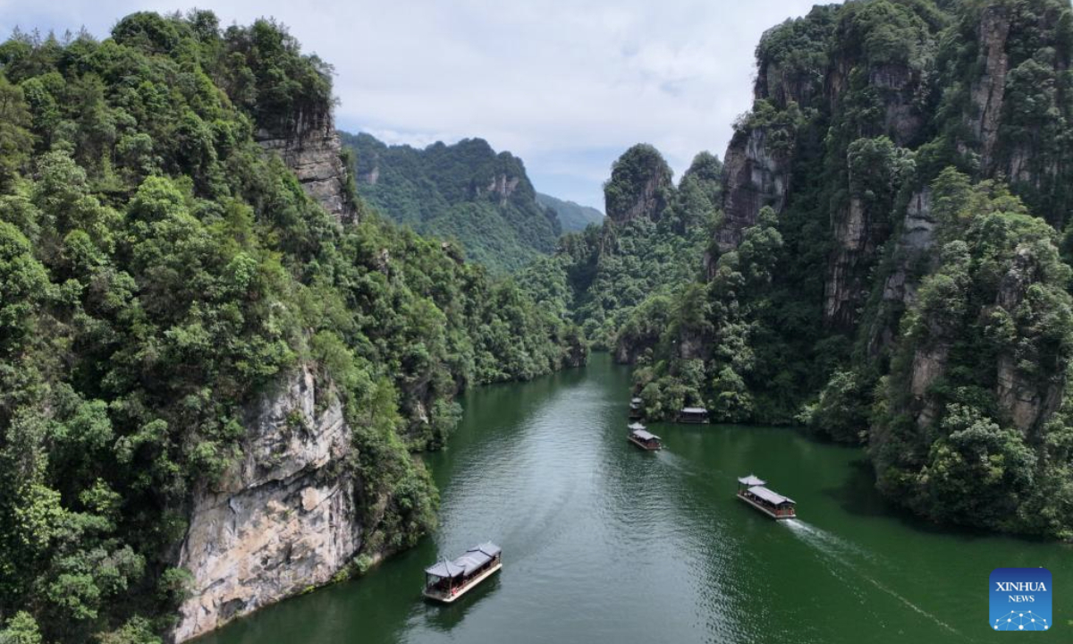 An aerial drone photo taken on June 16, 2025 shows tourists taking boats for sightseeing in the Baofeng Lake of Wulingyuan District in Zhangjiajie, central China's Hunan Province. (Photo by Wu Yongbing/Xinhua)