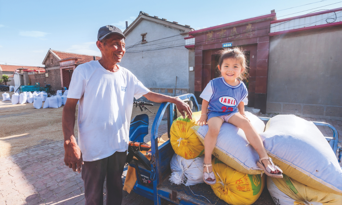 Villagers pose for a photo with newly harvested wheat in Cangzhou, North China's Hebei Province. Photo: Courtesy of China Rural Revitalization magazine