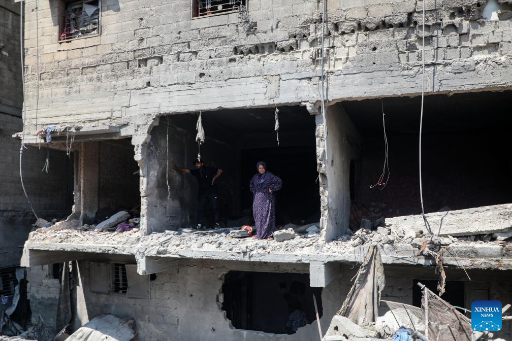 Palestinians stand inside a building destroyed in an Israeli airstrike in Gaza City, June 7, 2025. (Photo: Xinhua)