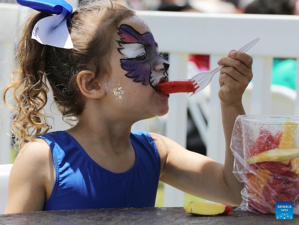 A girl enjoys watermelon during the 2025 California Watermelon Festival at the Hansen Dam Park in Los Angeles, California, the United States, June 7, 2025. (Photo: Xinhua)