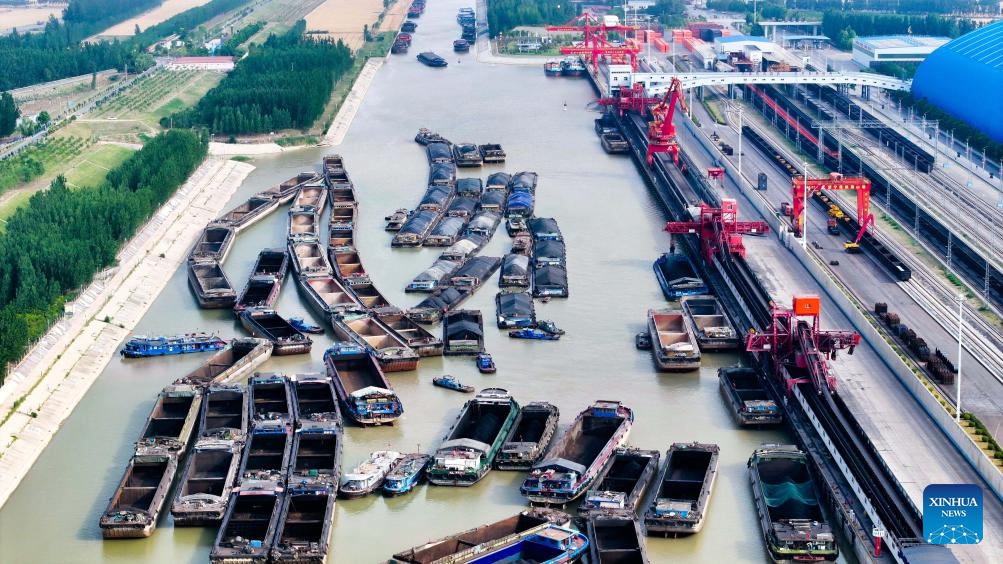 An aerial drone photo taken on June 8, 2025 shows ships docking for coal transportation at Liangshan Port in Jining, east China's Shandong Province. Liangshan Port serves as an important logistics hub connecting the western coal-producing areas with the Yangtze River Economic Belt. To ensure the coal supply during the peak demand period in summer, Liangshan Port has focused on streamlining the mining, storage, transportation and sales of coal. The port has put a transfer project into operation, which connects railway transportation with waterway transportation. (Photo: Xinhua)