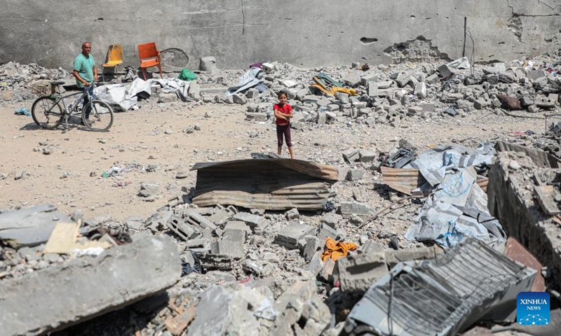 Palestinians are seen among the rubble of buildings destroyed in an Israeli airstrike in Gaza City, June 7, 2025. (Photo: Xinhua)