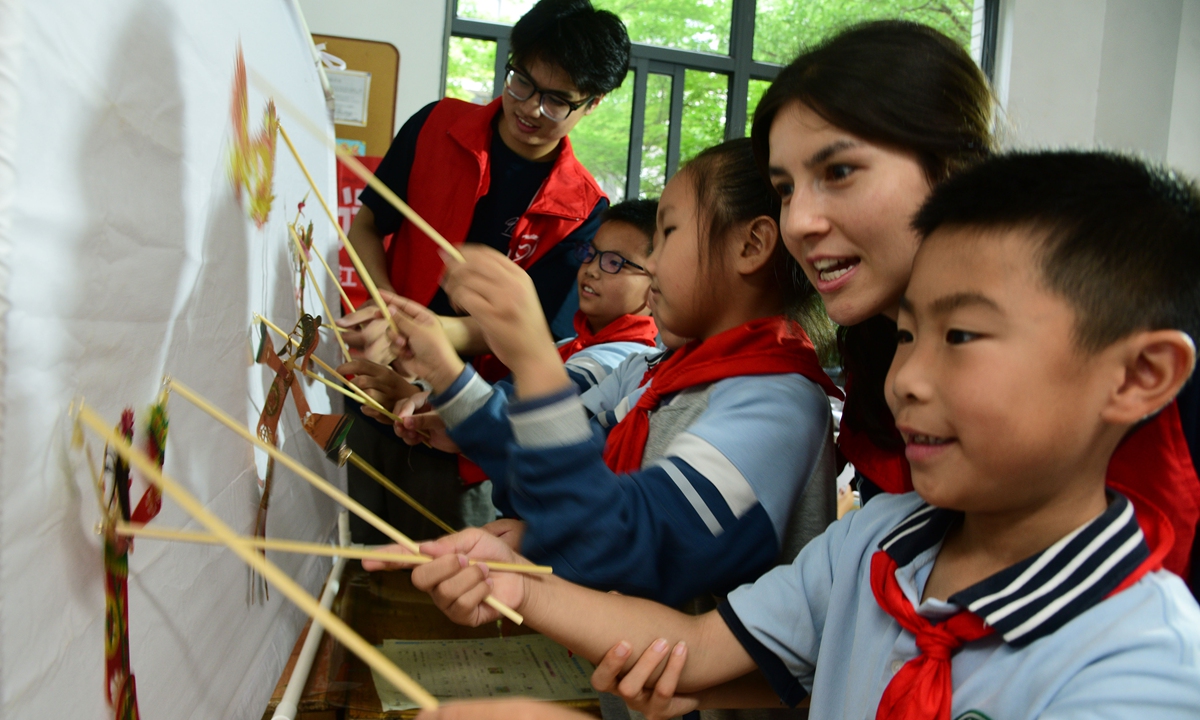 Primary school students learn to perform the shadow play <em>Nezha Conquers the Dragon King</em> under the guidance of volunteers from Jiangsu University in Zhenjiang, East China's Jiangsu Province on June 9, 2025. The volunteers helped the students to explore traditional shadow puppetry techniques, make shadow play figures and learn more about the intangible cultural heritage. Photo: VCG