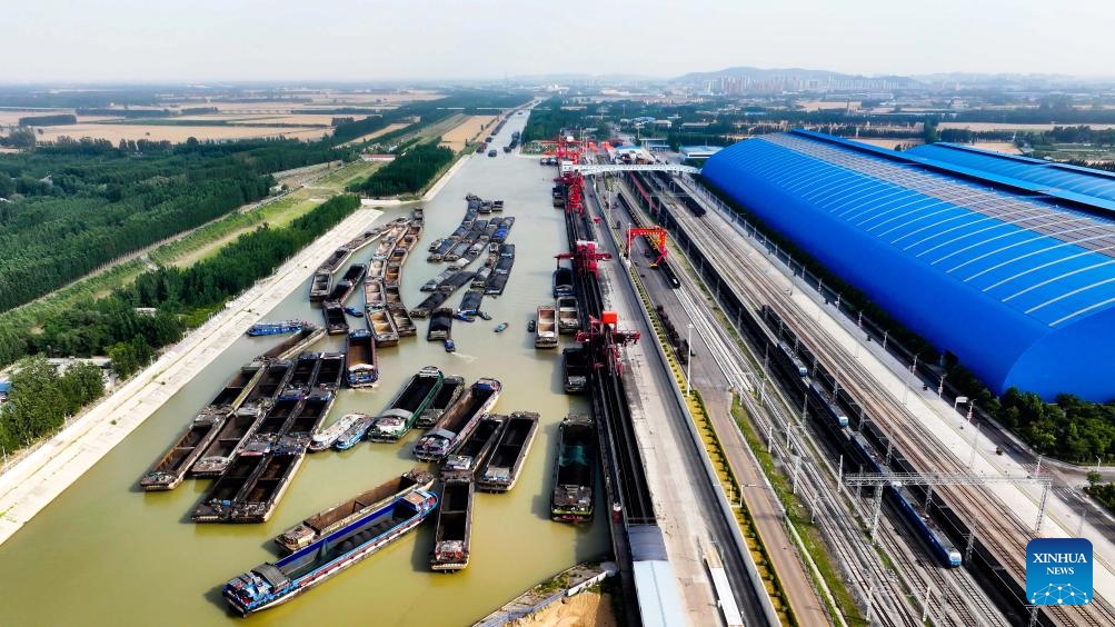 An aerial drone photo taken on June 8, 2025 shows ships docking for coal transportation at Liangshan Port in Jining, east China's Shandong Province. Liangshan Port serves as an important logistics hub connecting the western coal-producing areas with the Yangtze River Economic Belt. To ensure the coal supply during the peak demand period in summer, Liangshan Port has focused on streamlining the mining, storage, transportation and sales of coal. The port has put a transfer project into operation, which connects railway transportation with waterway transportation. (Photo: Xinhua)