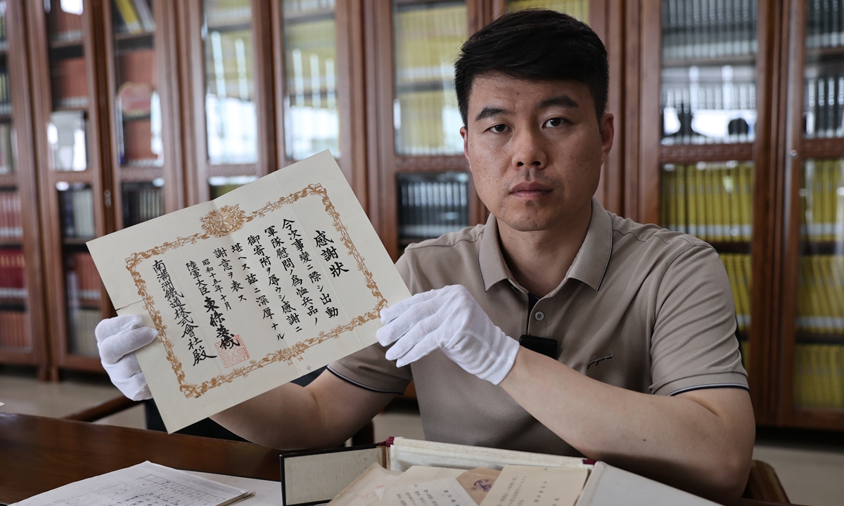 A staffer from the Liaoning Provincial Archives in Northeast China on June 12, 2025 displays the archival records of Japan's South Manchuria Railway Co, which was established in 1906 and ceased operations in 1945. The Archives has unveiled more than 1,200 historical files related to Japan's invasion during World War II, offering fresh evidence into Japan's military aggression and occupation of China over eight decades ago. Photo: VCG