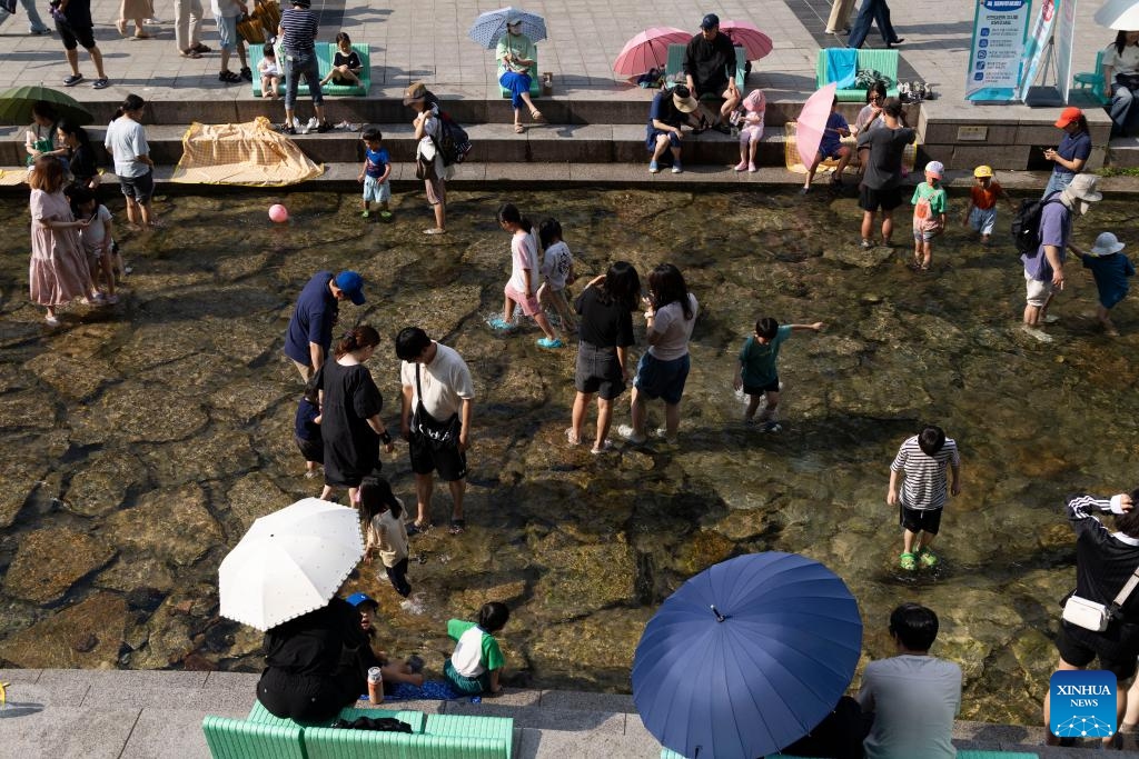 People cool themselves off at the Cheonggye stream, in Seoul, South Korea, June 14, 2025. (Photo: Xinhua)