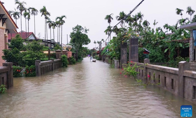 People wade through flood water in Hue city, central Vietnam, June 13, 2025. At least six people were killed and another remains missing in central Vietnam due to torrential rains and flooding triggered by Typhoon Wutip, the Vietnam Disaster and Dyke Management Authority said Sunday. (Photo: Xinhua)