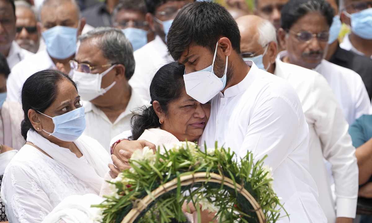 Rushabh Rupani, the son of former Chief Minister of Gujarat Vijay Rupani, who died in the Air India plane crash on June 12, consoles his mother as they receive his body in Ahmedabad, India, June 16, 2025. Photo: VCG