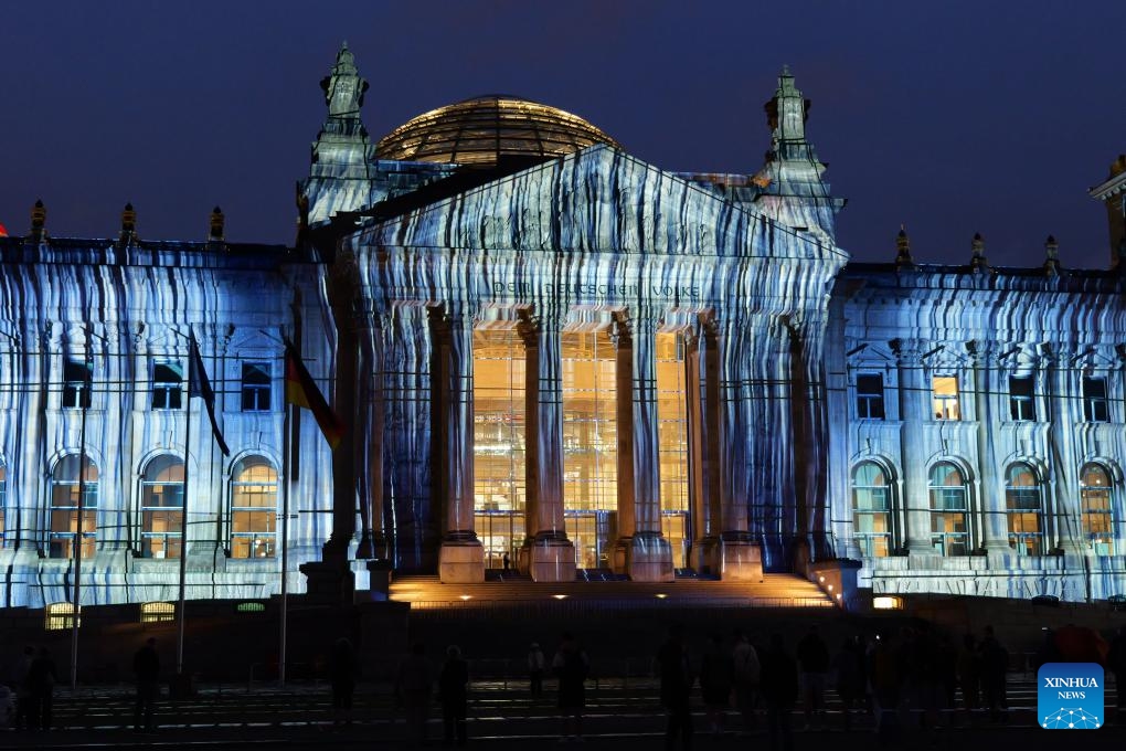 The Reichstag is seen illuminated in Berlin, Germany, June 15, 2025. In the midsummer nights of Berlin, the Reichstag is once again wrapped, not in fabric this time, but in light. From June 9 to June 20, 24 synchronized projectors illuminate the building's west facade, simulating the visual effect of massive fabric wrapping and unveiling. The light show is designed to commemorate the 30th anniversary of Bulgarian-born artist Christo and his wife Jeanne-Claude's iconic 1995 artwork, Wrapped Reichstag. (Photo: Xinhua)