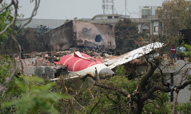 People stand beside the debris of an Air India plane crashed in Ahmedabad of India's Gujarat state, June 13, 2025. (Photo: Xinhua)