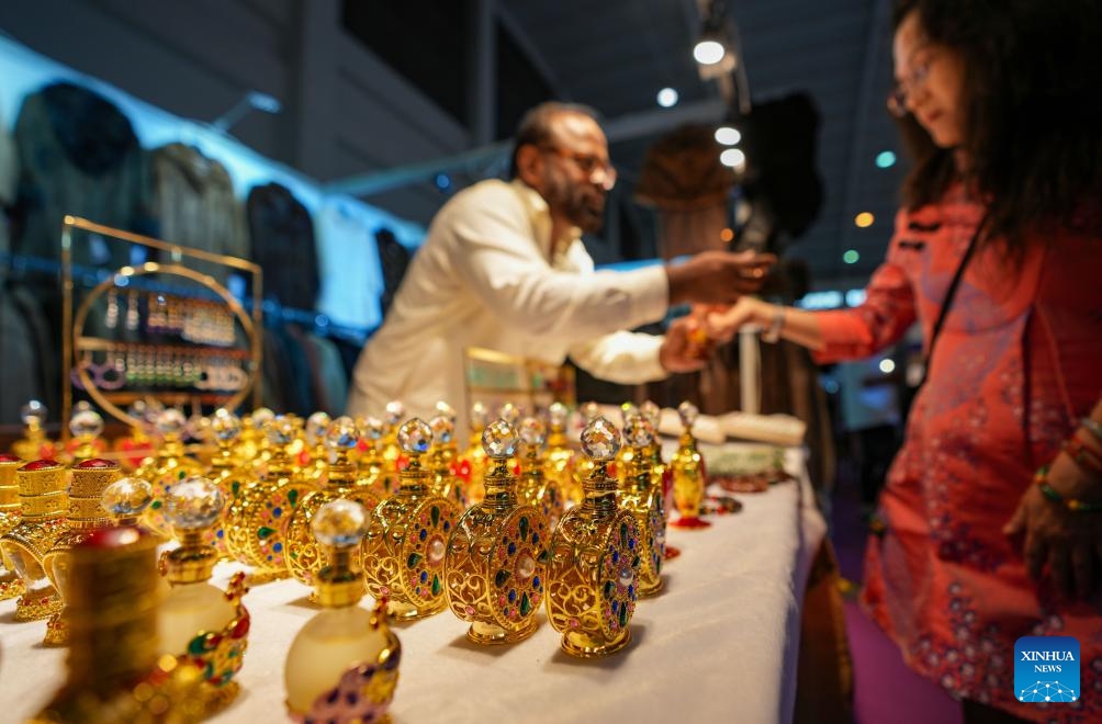A visitor tries perfume at the exhibition area of Bangladesh at the South Asia Pavilion during the 9th China-South Asia Expo in Kunming, southwest China's Yunnan Province, June 21, 2025. The six-day event, opened on Thursday in Kunming, features 16 exhibition halls. Nearly 500 enterprises from eight South Asian countries are participating in the event. (Photo: Xinhua)