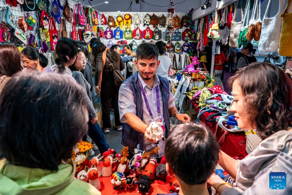 An exhibitor promotes products to visitors at the exhibition area of Nepal at the South Asia Pavilion during the 9th China-South Asia Expo in Kunming, southwest China's Yunnan Province, June 21, 2025. The six-day event, opened on Thursday in Kunming, features 16 exhibition halls. Nearly 500 enterprises from eight South Asian countries are participating in the event. (Photo: Xinhua)