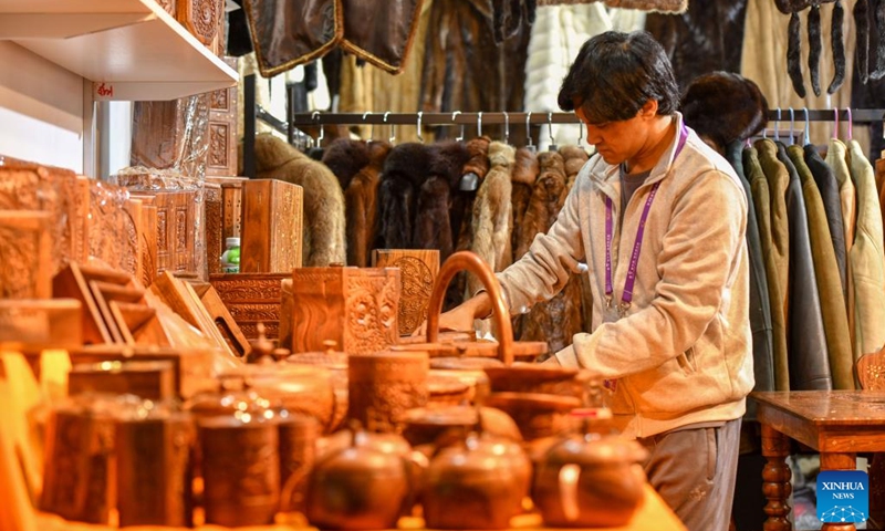An exhibitor arranges products at the exhibition area of Pakistan at the South Asia Pavilion during the 9th China-South Asia Expo in Kunming, southwest China's Yunnan Province, June 21, 2025. The six-day event, opened on Thursday in Kunming, features 16 exhibition halls. Nearly 500 enterprises from eight South Asian countries are participating in the event. (Photo: Xinhua)