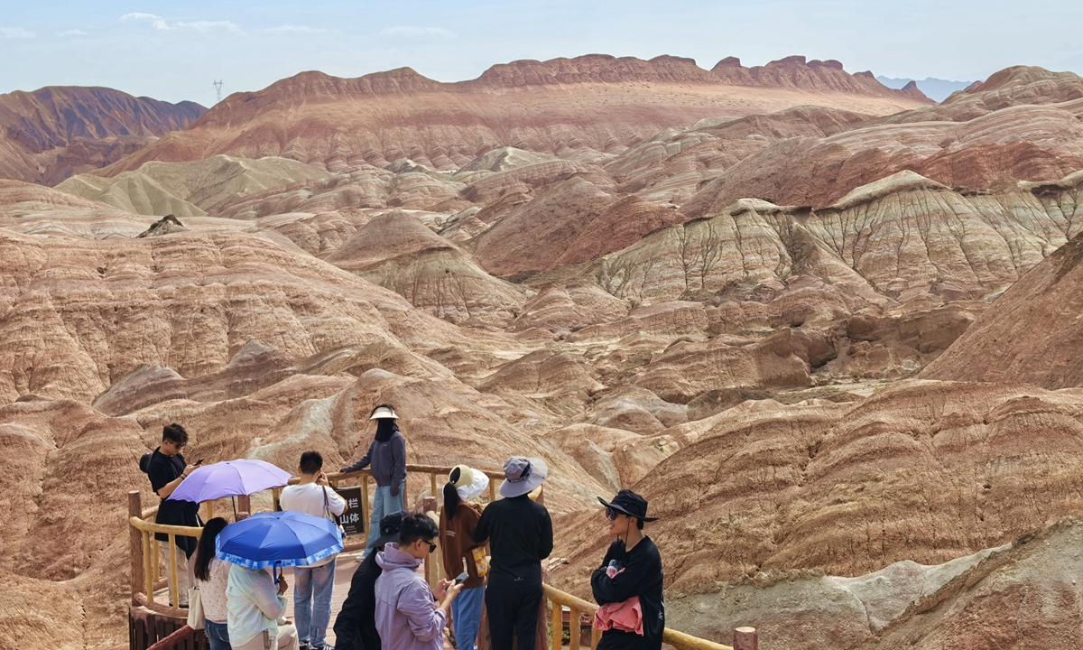 People admire the unique landscape at the Danxia National Geological Park in Zhangye, Northwest China's Gansu Province on June 22, 2025. In the first four months of this year, the province saw an uptick in the number of inbound tourists, receiving 48,426 overseas visitors, an increase of 52.6 percent year-on-year, according to local media reports. Photo: cnsphoto