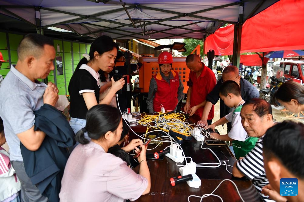 Citizens charge their devices at a temporary shelter in Longshan County, central China's Hunan Province, June 21, 2025. Torrential rainfall hit Longshan County in recent days. Disaster relief work is underway in the county as the rain weakened. (Photo: Xinhua)