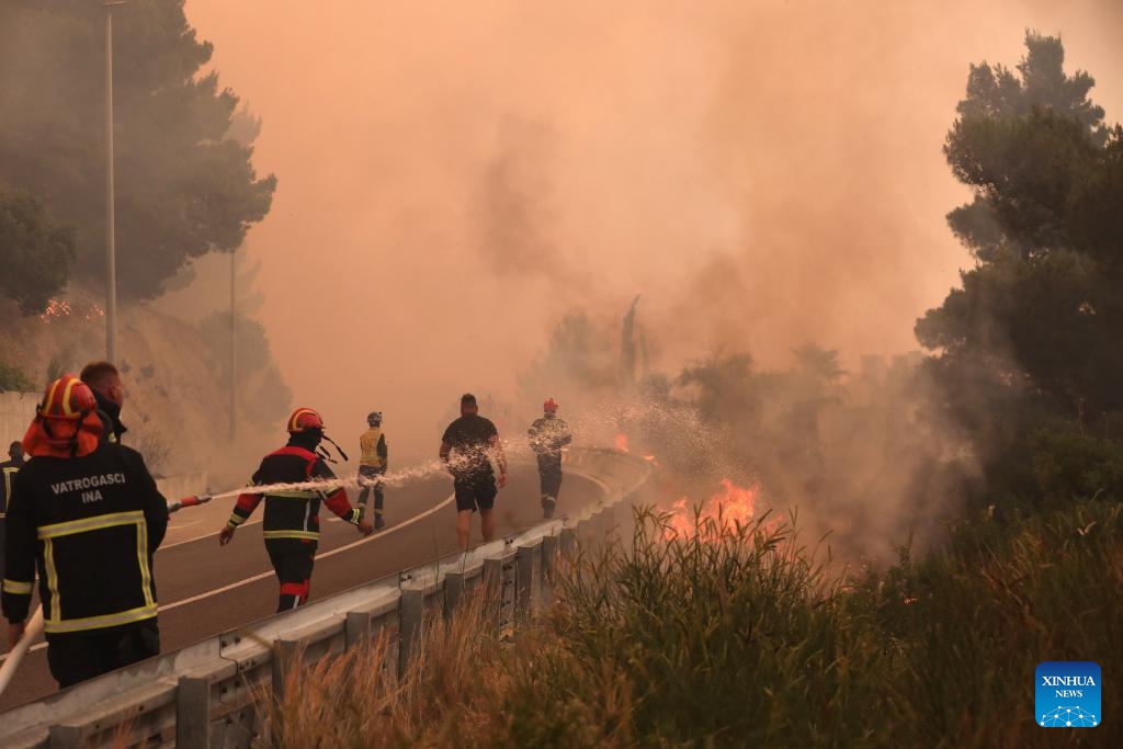 Firefighters spray water to extinguish the fire in Pisak, Croatia on June 21, 2025. (Photo: Xinhua)