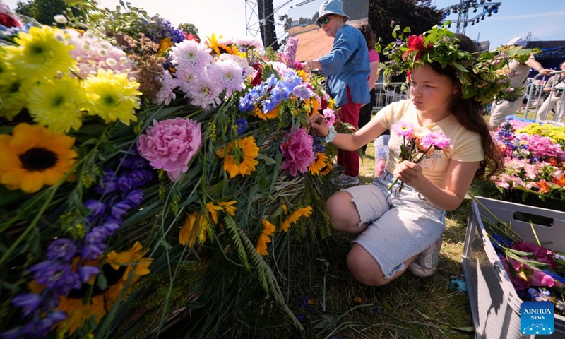 Residents weave a floral wreath during the Wianki Festival celebration in Warsaw, Poland, June 21, 2025. The event is a local tradition to mark the summer solstice, blending folklore, music, and modern festivities. (Photo: Xinhua)