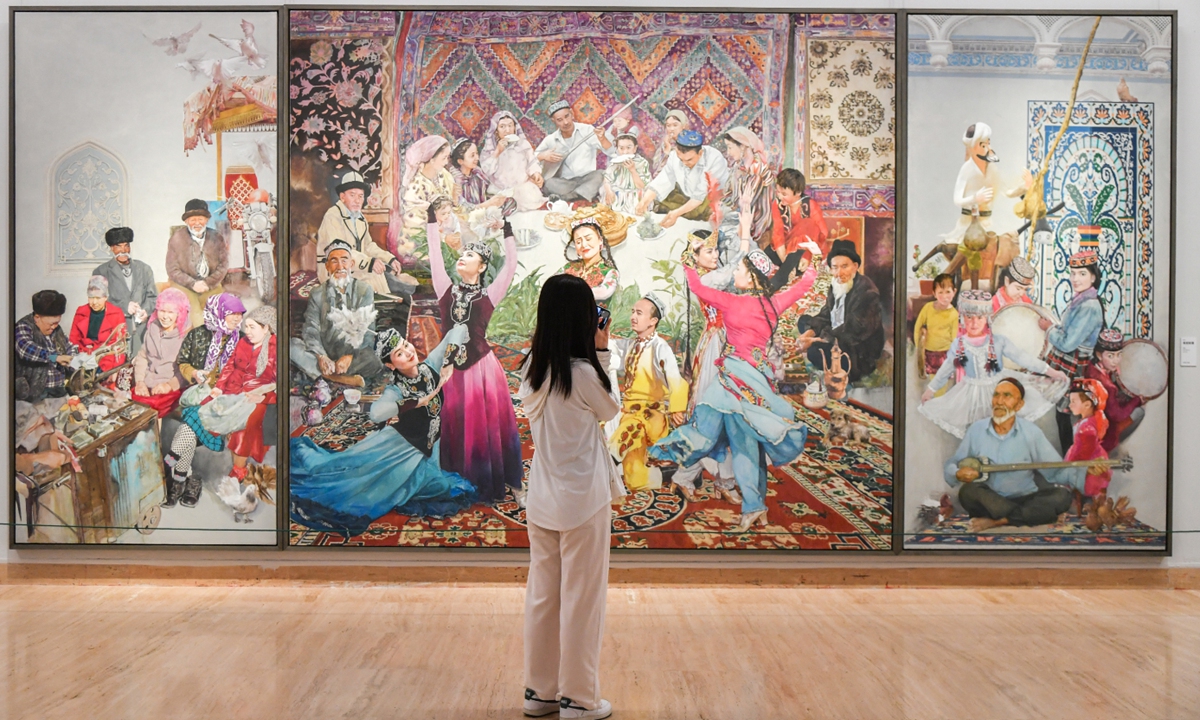 A visitor admires an oil painting titled Beautiful Xinjiang by artist Li Dan at an exhibition at the National Art Museum of China in Beijing on June 24, 2025. Held in celebration of the 70th anniversary of the establishment of the Xinjiang Uygur Autonomous Region and the 60th anniversary of the Xizang Autonomous Region, the exhibition features over 300 artworks across various mediums such as Chinese painting, oil painting, printmaking, and sculpture. Photo: VCG