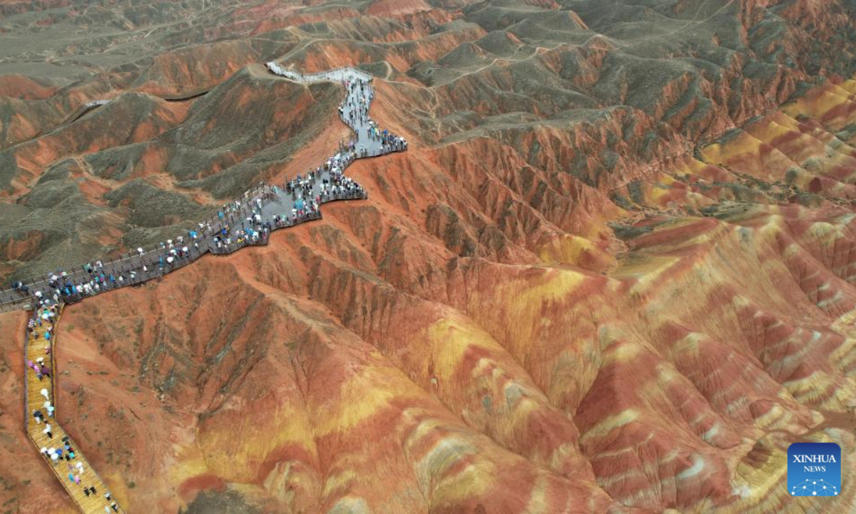 An aerial drone photo taken on June 22, 2025 shows tourists enjoying the scenery of Danxia landform in the rain at the Danxia National Geological Park in Zhangye, northwest China's Gansu Province. (Xinhua/Chen Bin)