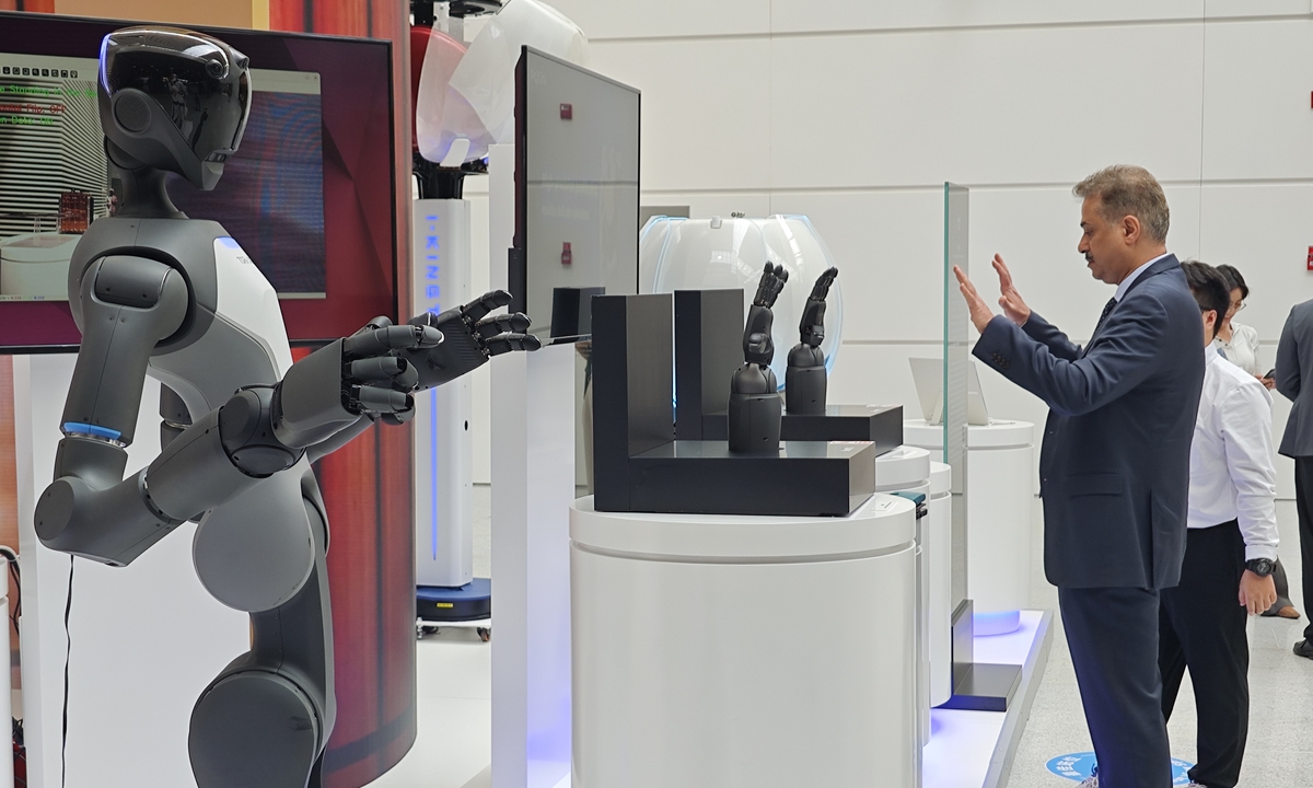 A person interacts with a robot at the 16th Annual Meeting of the New Champions of the World Economic Forum in North China's Tianjin on June 24, 2025. Photo: Yin Yeping/GT