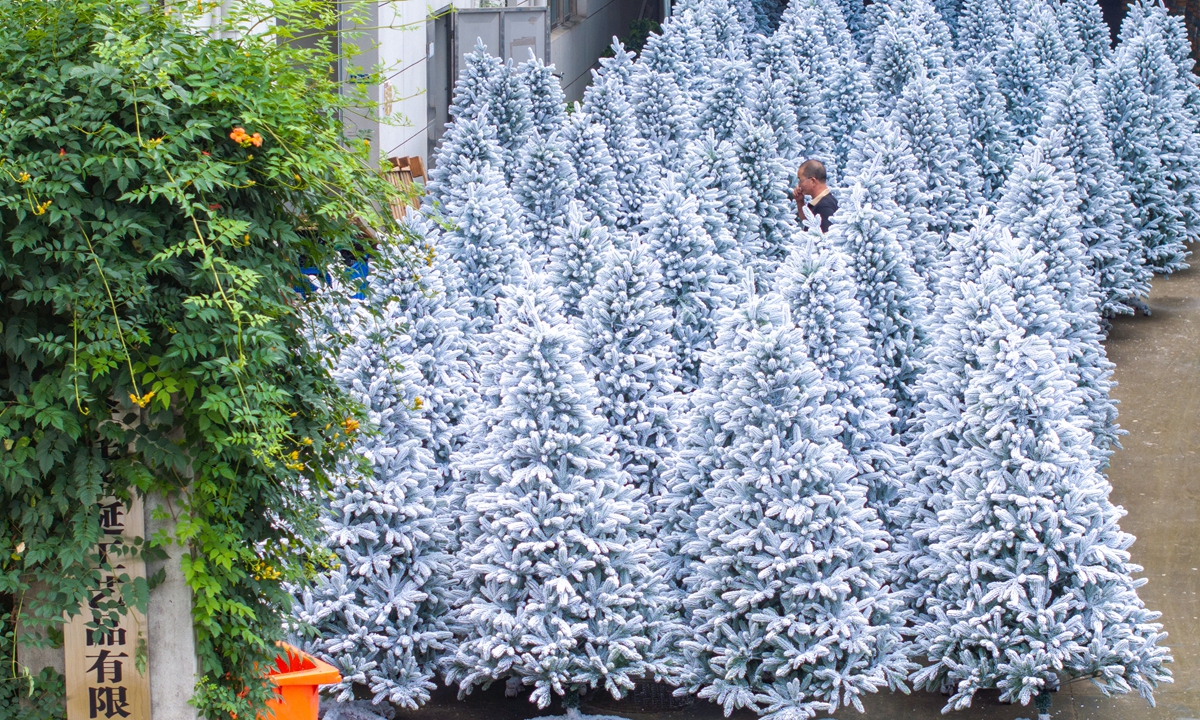 A worker walks among a forest of newly produced Christmas trees at a workshop in Jinhua, East China's Zhejiang Province on June 25, 2025. In the first four months of 2025, small commodity hub Yiwu in Zhejiang exported 200 million yuan ($27.89 million) worth of Christmas goods, up 32.5 percent year-on-year, according to a local media outlet. Photo: VCG