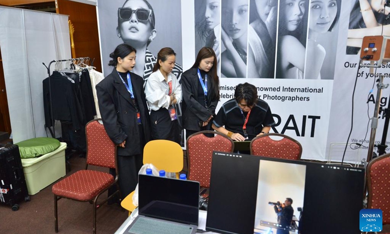 Staff members of a Chinese photograph company are pictured at the 31st Consumer Fair & Trade Expo (CFTE) of Brunei in Bandar Seri Begawan, Brunei, June 25, 2025. The 31st CFTE of Brunei opened at the International Convention Center here on Wednesday, attracting over 350 exhibitors and more than 600 booths. Brunei's biggest consumer fair, CFTE is being held from June 25 to June 29, alongside the 2nd Consumer Fair Conference (CONFAC). (Photo: Xinhua)