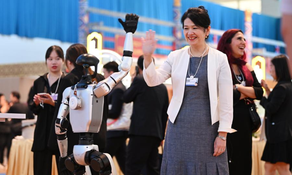 A guest interacts with a robot during the Cultural Soiree of the 16th Annual Meeting of the New Champions, also known as the Summer Davos, in north China's Tianjin Municipality, June 25, 2025. (Xinhua/Li Ran)