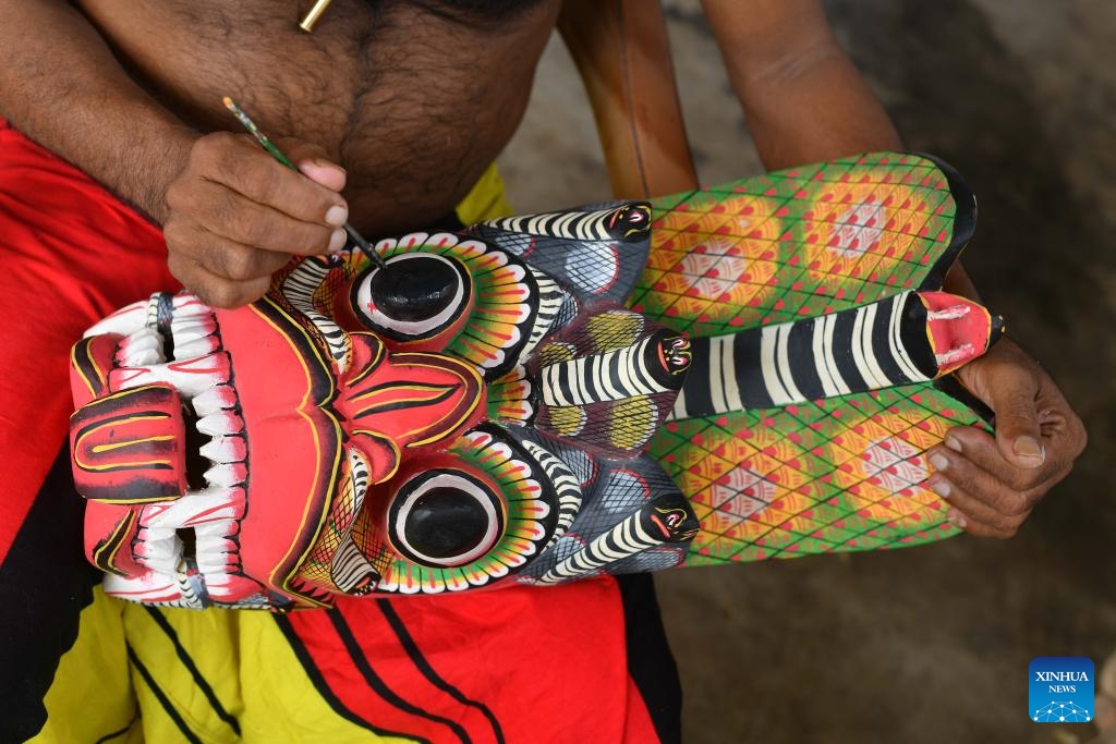 A traditional Sri Lankan mask maker paints a wooden mask in Gonapola village, Sri Lanka on June 25, 2025. The southern region of Sri Lanka, especially south of Colombo, is famous for the making and use of wooden masks, which play an important role in rituals and dances. (Photo: Xinhua)