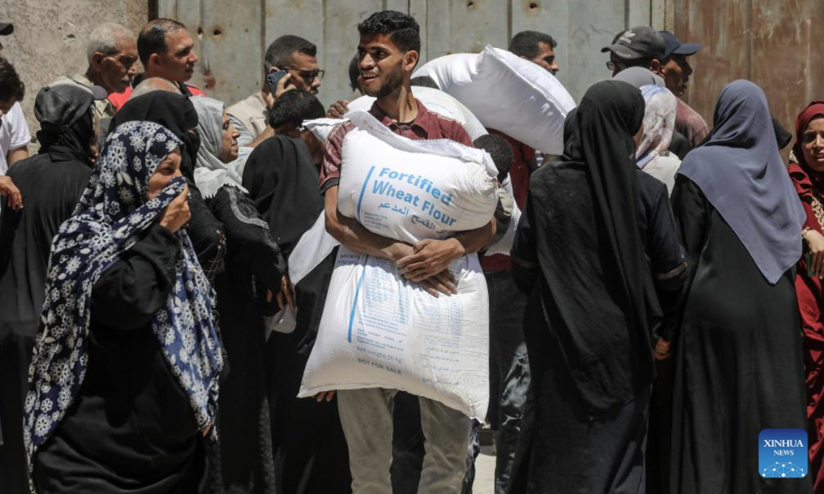 Palestinians gather to receive food aid at a food assistance distribution point in Gaza City, on June 26, 2025. (Photo by Rizek Abdeljawad/Xinhua)