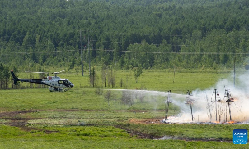 A helicopter water bombs a fire during a drill in the Dahinggan Mountains, northeast China's Heilongjiang Province, June 24, 2025. Local fire brigades conducted a fire drill in the Dahinggan Mountains on Tuesday to improve their preparedness and response mechanism. The drill featured four typical scenarios, namely emergence response, fighting primitive forest fires, fighting fuel storage tank fires, and fighting high-rise building fires. (Photo: Xinhua)