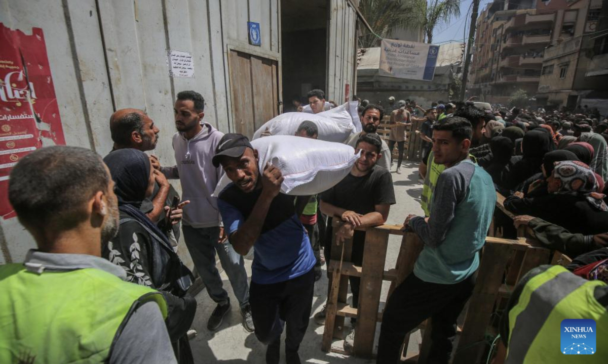 Palestinians gather to receive food aid at a food assistance distribution point in Gaza City, on June 26, 2025. (Photo by Rizek Abdeljawad/Xinhua)