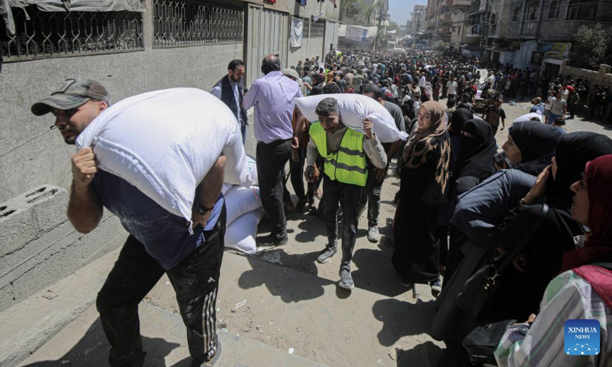 Palestinians gather to receive food aid at a food assistance distribution point in Gaza City, on June 26, 2025. (Photo by Rizek Abdeljawad/Xinhua)