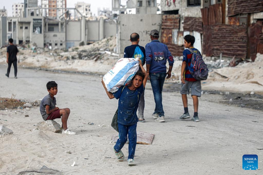 A Palestinian child carries a bag of collected firewood at a temporary shelter amid a long-time shortage of cooking gas and fuel in northern Gaza City, on June 24, 2025. (Photo: Xinhua)