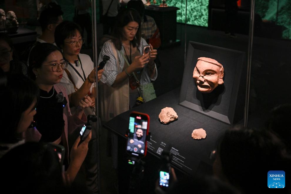 Visitors appreciate an exhibit during a media preview of the exhibition titled Legends of Dragon: The Ancient Civilization of Hongshan Culture at the Shanghai Museum East in east China's Shanghai, June 25, 2025. The exhibition will open here on June 26. The exhibition is jointly organized by twenty domestic museums and archaeological institutions, showcasing over 300 cultural relics. Hongshan culture is an important prehistoric archaeological culture dating back roughly 5,000 to 6,000 years. (Photo: Xinhua)