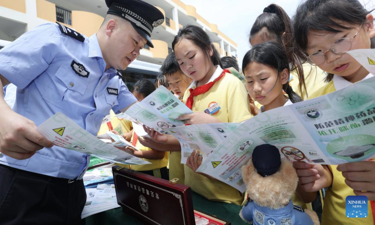 A police officer explains the danger of narcotics to students at a school in Daishan County of Zhoushan City, east China's Zhejiang Province, June 25, 2025. This year's June 26 marks the 38th International Day Against Drug Abuse and Illicit Trafficking. Publicity and education activities were held in many places in China to promote the anti-drug awareness. (Photo by Zou Xunyong/Xinhua)