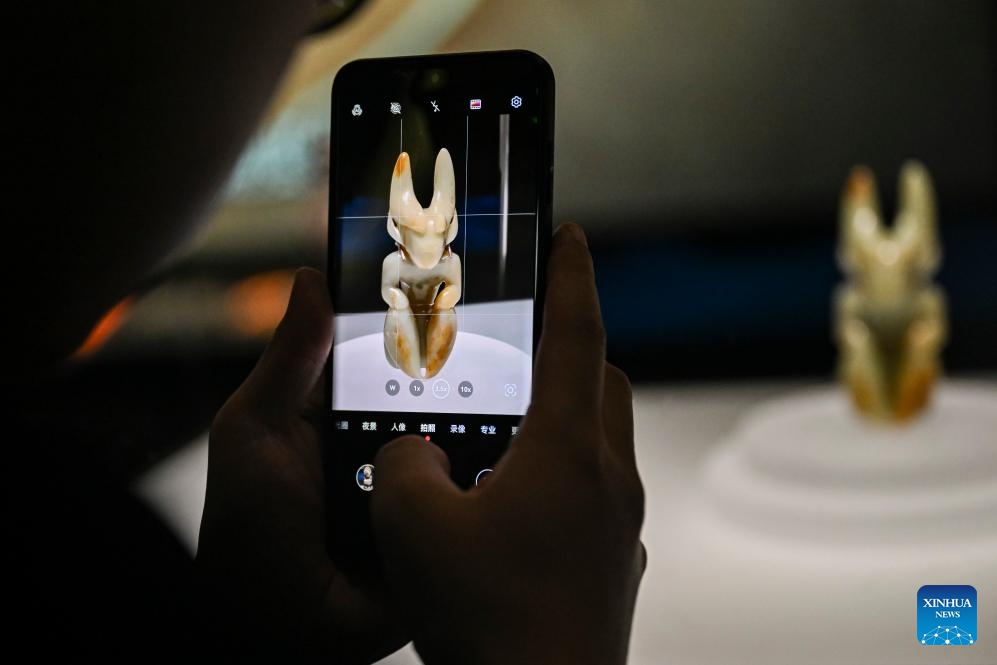 A visitor takes photos of an exhibit during a media preview of the exhibition titled Legends of Dragon: The Ancient Civilization of Hongshan Culture at the Shanghai Museum East in east China's Shanghai, June 25, 2025. The exhibition will open here on June 26. The exhibition is jointly organized by twenty domestic museums and archaeological institutions, showcasing over 300 cultural relics. Hongshan culture is an important prehistoric archaeological culture dating back roughly 5,000 to 6,000 years. (Photo: Xinhua)